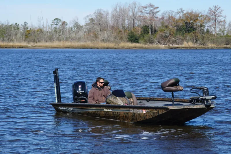 Slide: The Image of 2019 Ranger RT188P Fishing boat on a calm lake with a person onboard. - 6