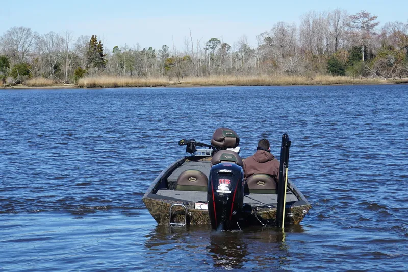 Slide: The Image of 2019 Ranger RT188P Fishing boat on a serene lake with two passengers. - 8