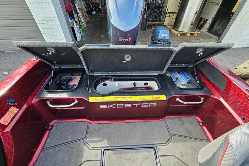 Slide: The Image of 2023 Skeeter WX2200 boat with open storage compartments and visible engine. - 18