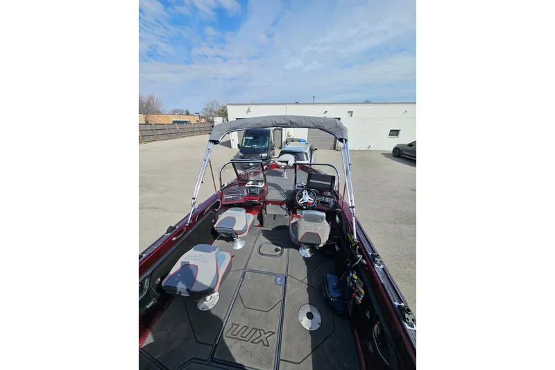 Slide: The Image of 2023 Skeeter WX2200 boat interior with seating and steering console, parked outdoors. - 23