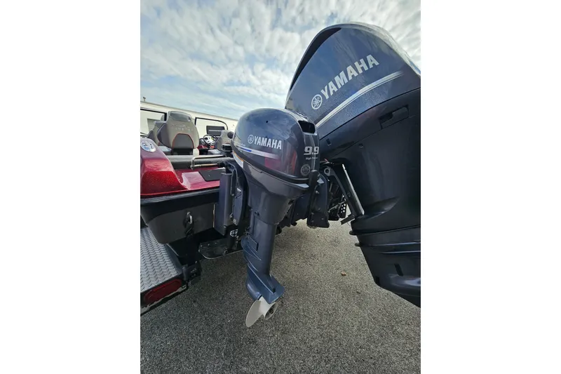 Slide: The Image of 2023 Skeeter WX2200 boat with Yamaha outboard motor, parked on pavement under cloudy sky. - 9