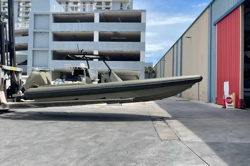 Slide: The Image of 2022 Technohull T9 boat being lifted by a forklift in an industrial area. - 12