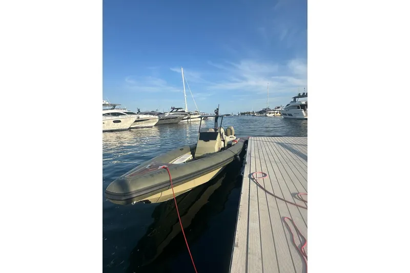 Slide: The Image of 2022 Technohull T9 boat docked at marina, surrounded by yachts under clear blue sky. - 17