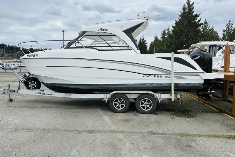 The Image of 2020 Beneteau Antares 7 boat on trailer, parked outdoors, cloudy sky background. - 0