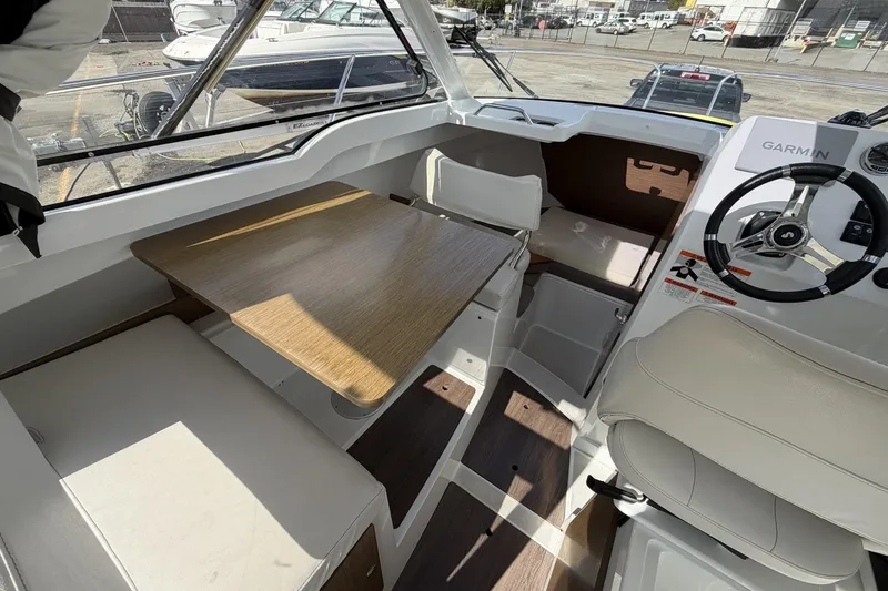 Slide: The Image of Interior of 2020 Beneteau Antares 7 boat with seating, table, and steering wheel. - 13