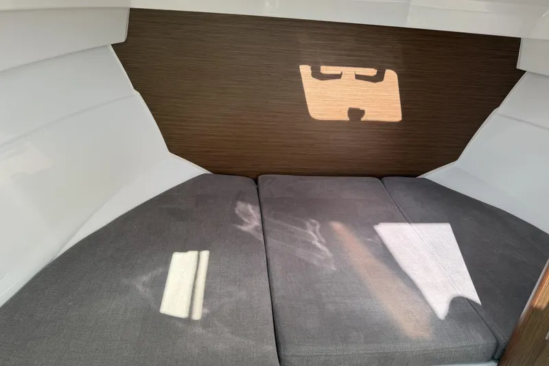 Slide: The Image of Interior cabin of 2020 Beneteau Antares 7 with gray cushions and wooden paneling. - 14