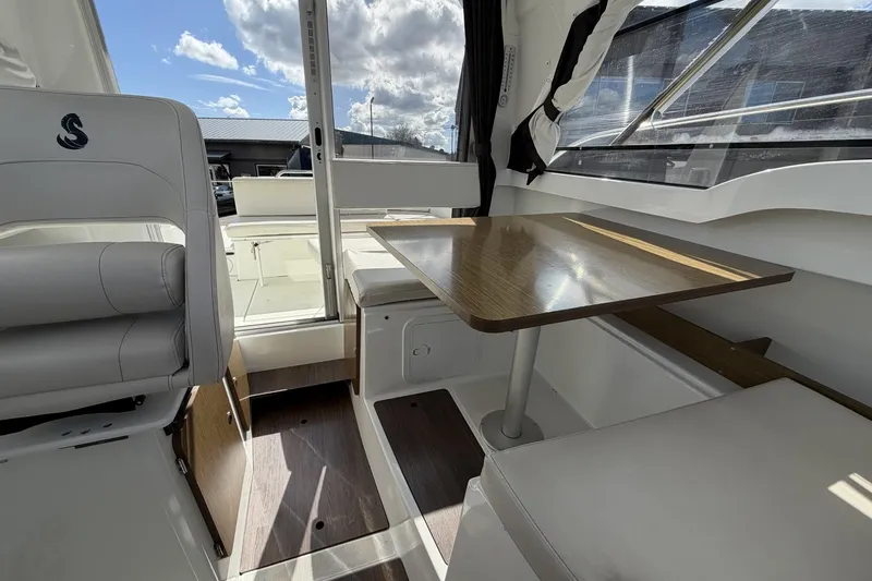 Slide: The Image of Interior of 2020 Beneteau Antares 7 boat with seating and wooden table. - 16