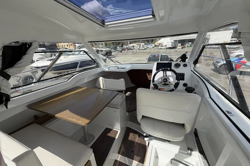 Slide: The Image of Interior of 2020 Beneteau Antares 7 boat with steering wheel and seating area. - 17
