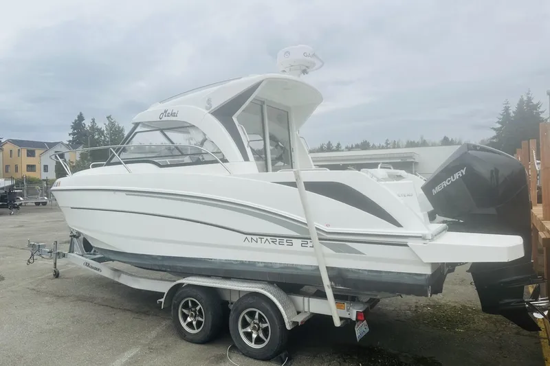 Slide: The Image of 2020 Beneteau Antares 7 boat on trailer with Mercury engine, parked outdoors. - 2