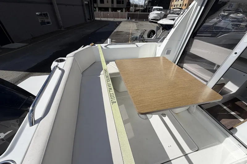 Slide: The Image of 2020 Beneteau Antares 7 boat deck with seating and wooden table. - 5