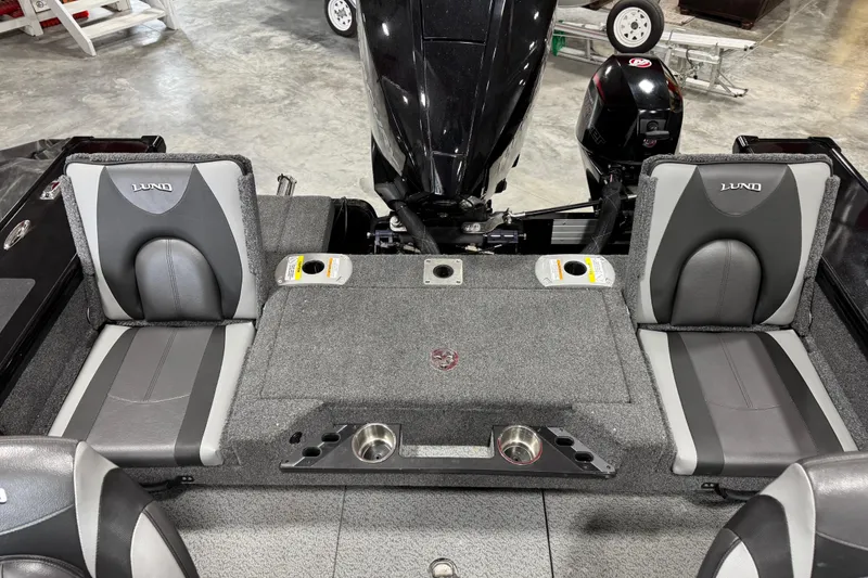 Slide: The Image of 2024 Lund 2075 Pro-V boat interior with gray seating and motor view. - 13