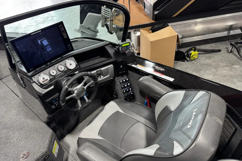 Slide: The Image of 2024 Lund 2075 Pro-V boat cockpit with steering wheel, gauges, and comfortable seating. - 15