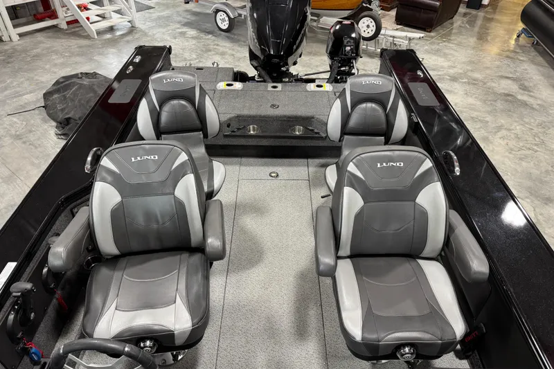 Slide: The Image of 2024 Lund 2075 Pro-V boat interior with four gray seats in a showroom. - 16