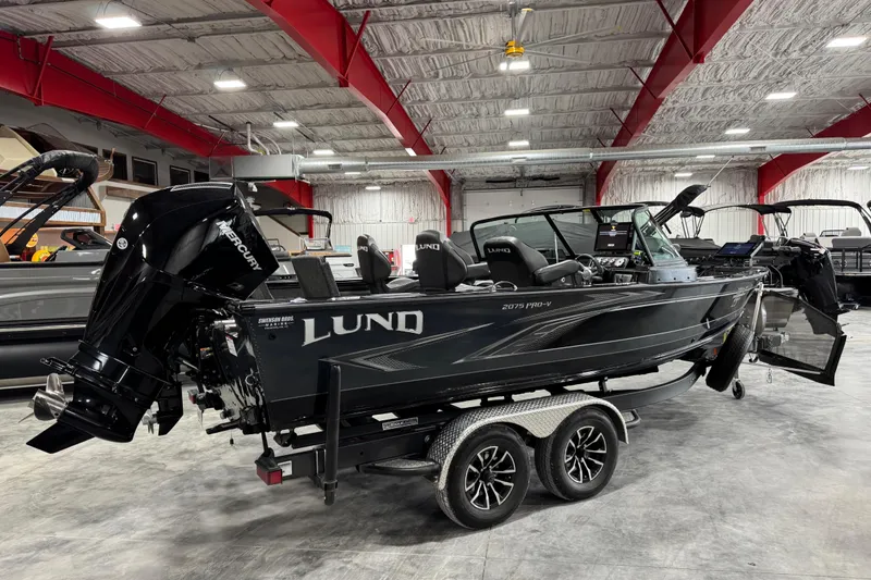 Slide: The Image of 2024 Lund 2075 Pro-V boat in showroom, featuring sleek design and powerful Mercury engine. - 4