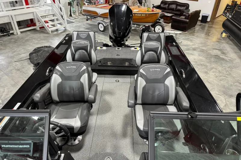 Slide: The Image of 2024 Lund 2075 Pro-V boat interior with four seats in a showroom setting. - 6