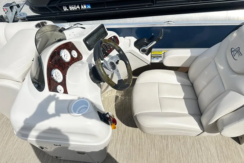 Slide: The Image of 2014 Misty Harbor 2286 Pontoon boat interior with steering console and plush seating. - 6