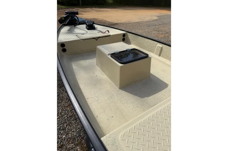 Slide: The Image of 2026 Santee 160 Tiller Steer boat interior with storage compartment and textured flooring. - 2