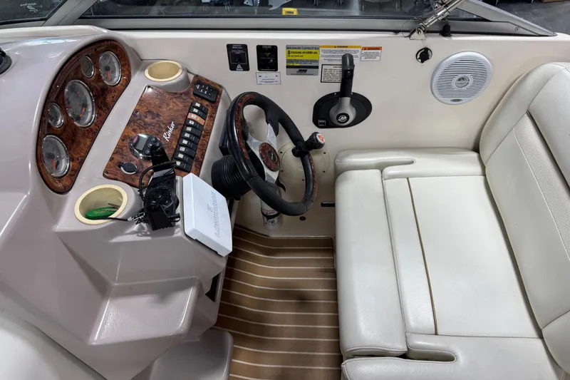 Slide: The Image of 2006 Rinker Fiesta Vee 250 boat cockpit with steering wheel and control panel. - 11