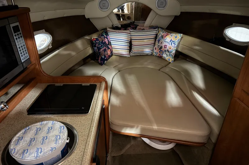 Slide: The Image of 2006 Rinker Fiesta Vee 250 cabin interior with cozy seating and colorful pillows. - 14