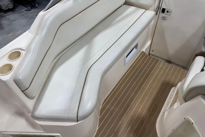 Slide: The Image of 2006 Rinker Fiesta Vee 250 boat interior with white seating and wood-patterned flooring. - 7