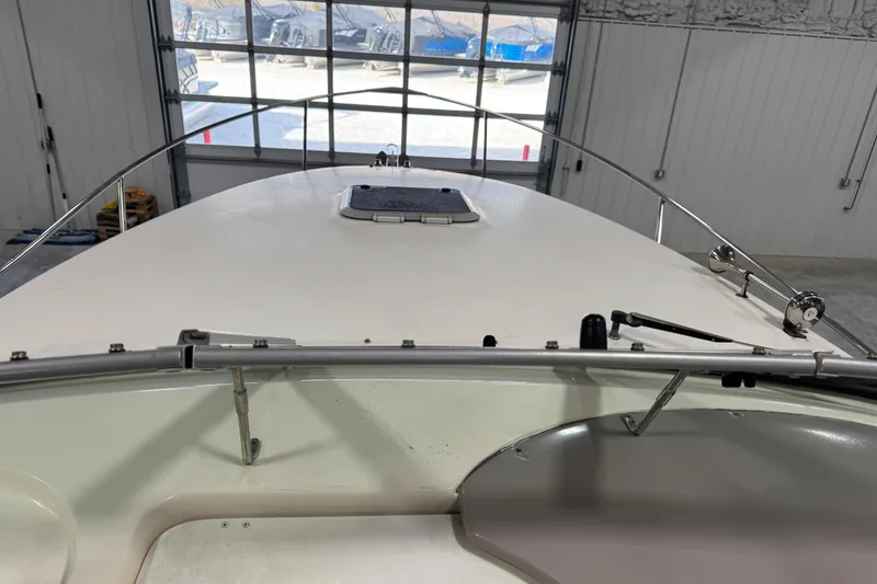 Slide: The Image of 2006 Rinker Fiesta Vee 250 boat interior, showing bow and railing in a garage setting. - 8