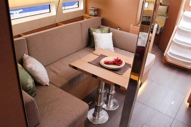 Slide: The Image of Interior of 2025 Jeanneau Sun Odyssey 440 yacht, featuring cozy seating and elegant dining area. - 14