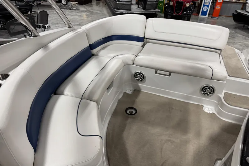 Slide: The Image of 2008 Crownline 300 LS boat interior with white and blue seating, speakers, and carpeted floor. - 14