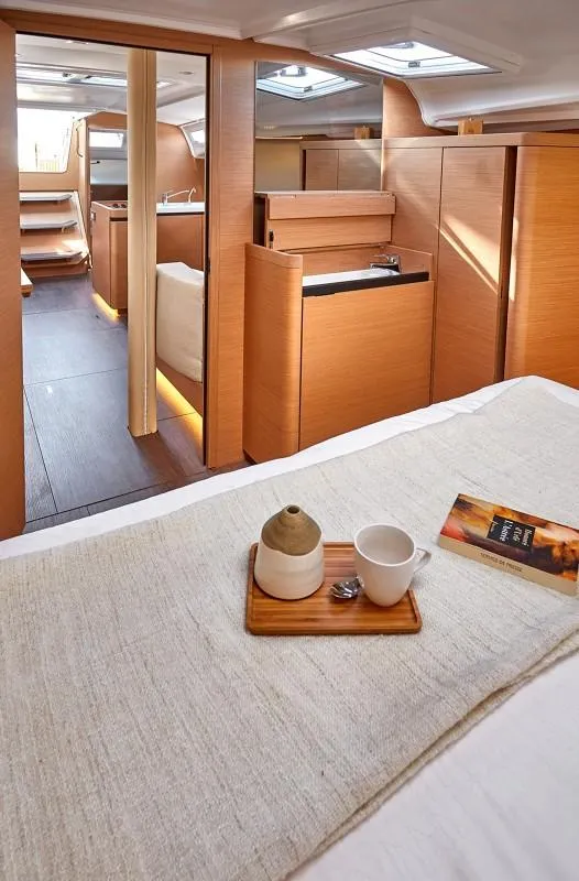 Slide: The Image of 2025 Jeanneau Sun Odyssey 410 interior, featuring a cozy cabin with modern wooden finishes. - 10