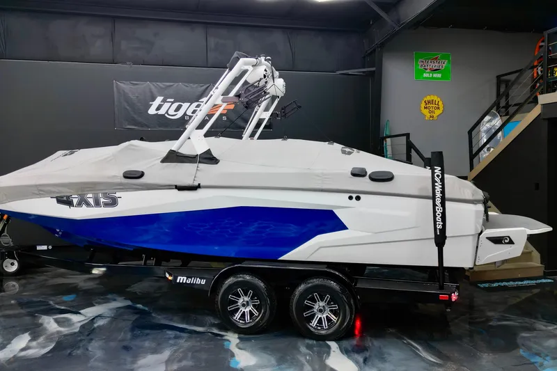 Slide: The Image of 2023 Axis A225 boat with cover on trailer in showroom. - 13