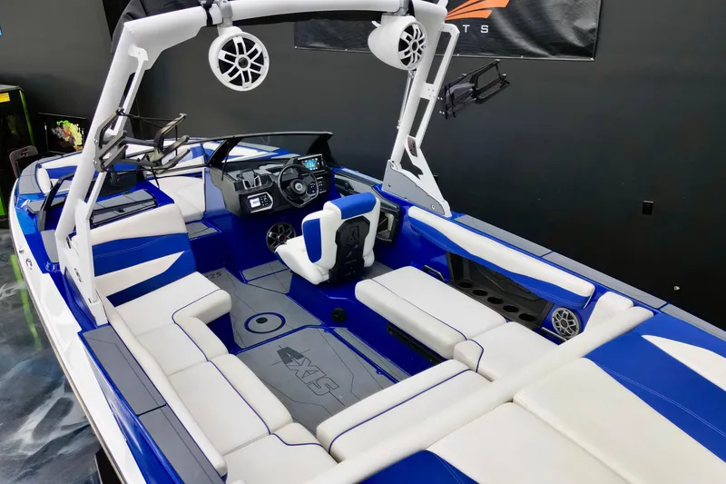 Slide: The Image of 2023 Axis A225 boat interior with blue and white seating, advanced dashboard, and speakers. - 5