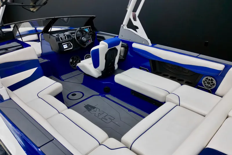 Slide: The Image of 2023 Axis A225 boat interior with blue and white seating, modern dashboard, and spacious layout. - 8