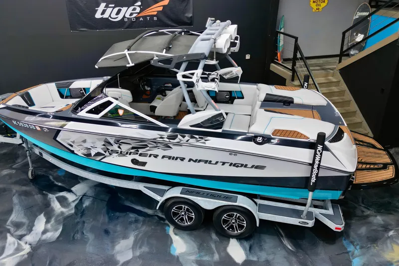 Slide: The Image of 2014 Nautique Super Air Nautique G21 boat on trailer in showroom setting. - 11