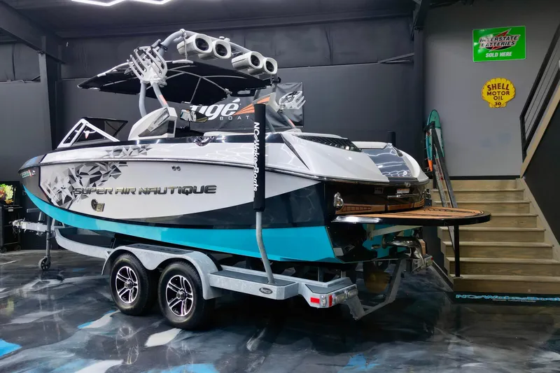 Slide: The Image of 2014 Nautique Super Air Nautique G21 boat on trailer in showroom setting. - 8