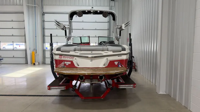 Slide: The Image of Red 2019 MasterCraft XT20 boat in a garage. - 4