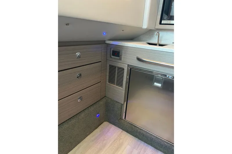 Slide: The Image of 2019 Formula 350 Crossover Bowrider I/O interior with modern cabinetry and compact kitchenette. - 10