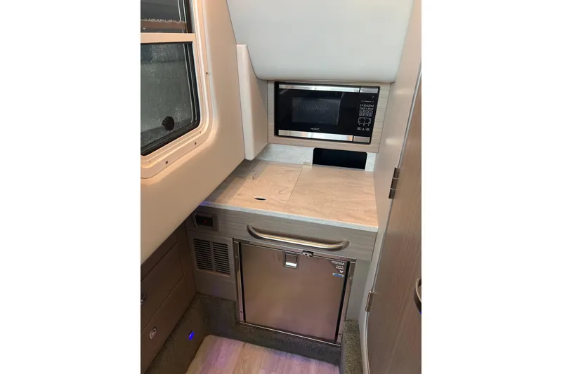 Slide: The Image of 2019 Formula 350 Crossover Bowrider I/O interior with microwave and compact fridge. - 17
