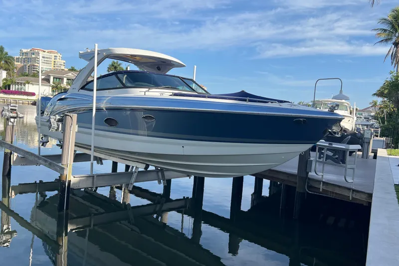 Slide: The Image of 2019 Formula 350 Crossover Bowrider I/O on lift at marina, clear sky background. - 2