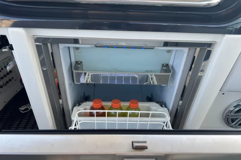 Slide: The Image of Open mini fridge on 2019 Formula 350 Crossover Bowrider I/O, containing bottled drinks. - 22