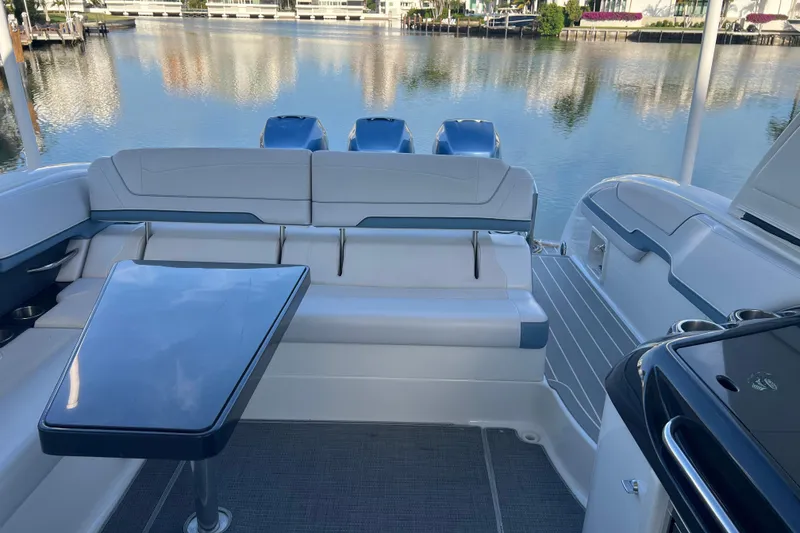 Slide: The Image of 2019 Formula 350 Crossover Bowrider I/O interior with seating and table, overlooking calm waters. - 34