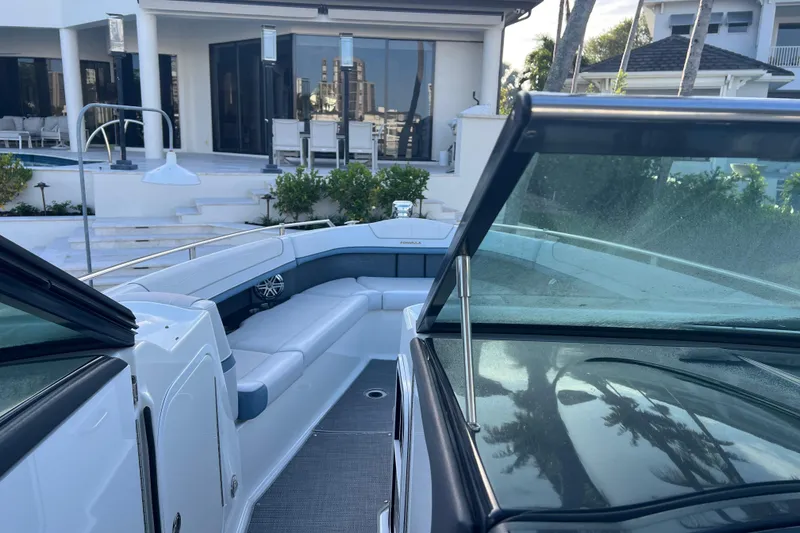 Slide: The Image of 2019 Formula 350 Crossover Bowrider I/O boat docked near a modern waterfront home. - 41