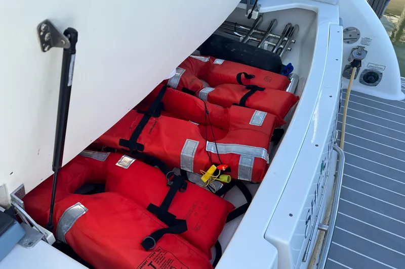 Slide: The Image of Storage compartment with red life jackets on a 2019 Formula 350 Crossover Bowrider I/O boat. - 77