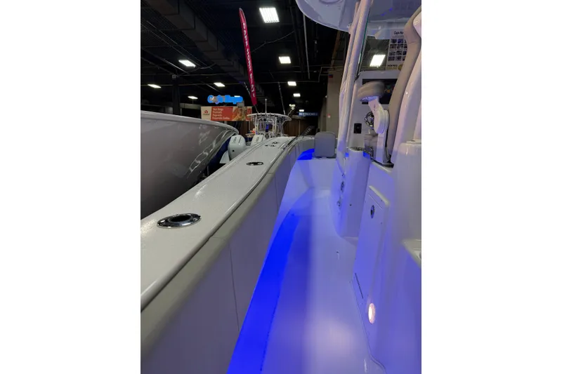 Slide: The Image of 2026 Cape Horn 28 XS boat interior with blue LED lighting at a showroom. - 11