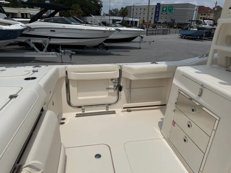 Slide: The Image of The image shows the cockpit of a Grady-White Canyon 326 boat. It features white upholstery and multiple storage compartments. - 16