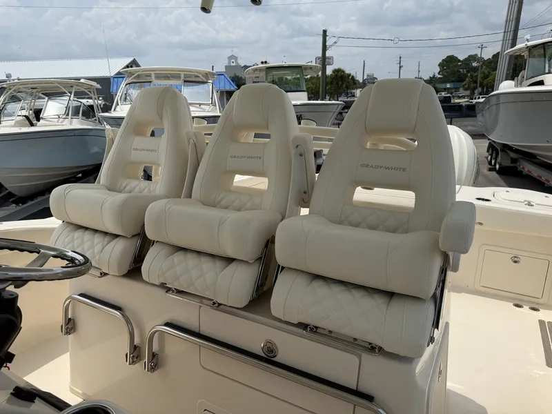 Slide: The Image of Three luxurious, cushioned seats with Grady-White logo on a boat, surrounded by other boats in a marina. - 22