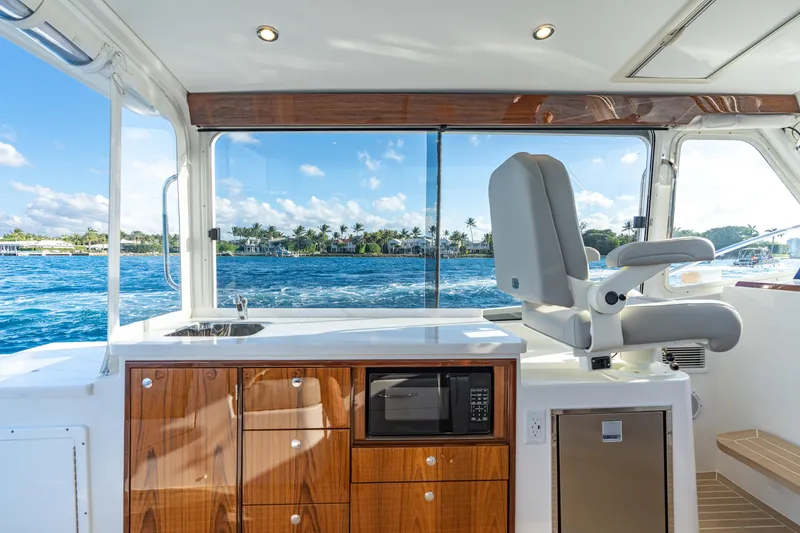 Slide: The Image of Interior of 2026 MJM 38RS yacht with ocean view, featuring helm seat and kitchenette. - 8