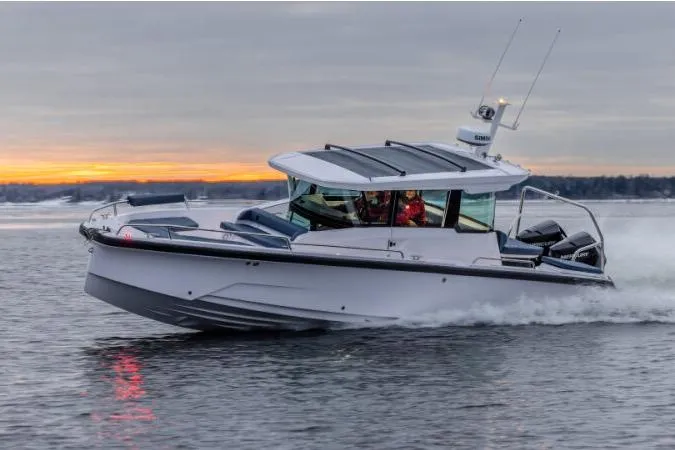 The Image of 2027 Axopar 29 XC Cross Cabin boat cruising at sunset on calm waters. - 1