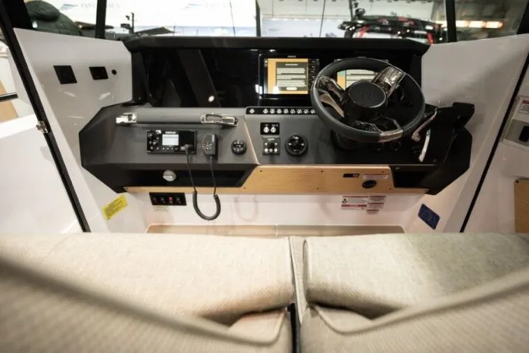 Slide: The Image of 2027 Axopar 29 XC Cross Cabin helm with modern controls and steering wheel. - 10