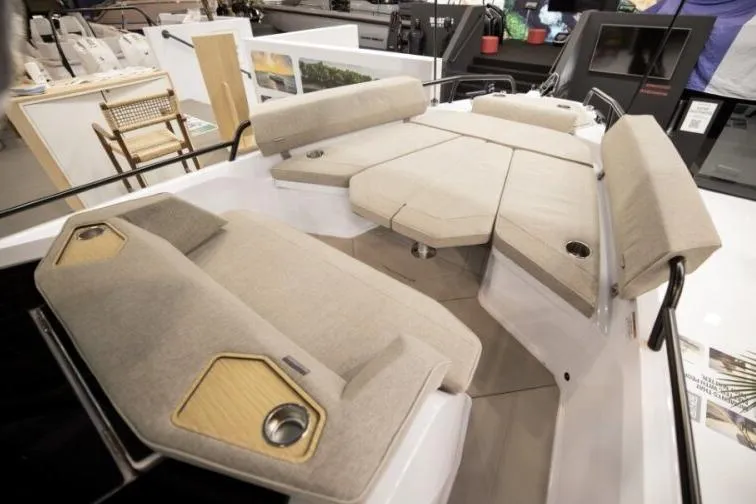 Slide: The Image of 2027 Axopar 29 XC Cross Cabin boat interior with beige cushioned seating and modern design. - 7