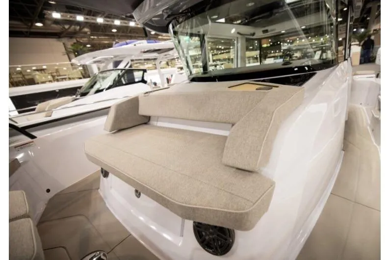 Slide: The Image of 2027 Axopar 29 XC Cross Cabin boat interior with cushioned seating at a boat show. - 8