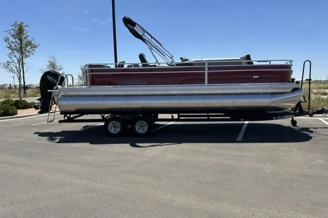 Slide: The Image of 2026 Sun Tracker Sportfish 24 XP3 pontoon boat on trailer in parking lot. - 27